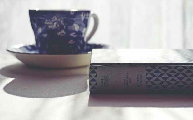 floral ceramic mug beside a book